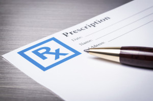 Closeup of a prescription form with a pen on a stainless steel background