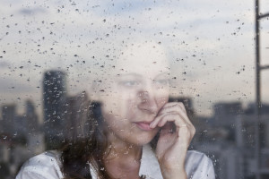 Melancholy reflection of the girl in the window