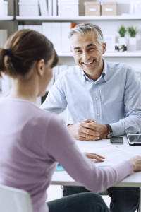 Mature businessman and young woman having a business meeting in the office, they are discussing together