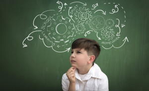 schoolboy thinking about obligations, draw gear mechanism on blackboard