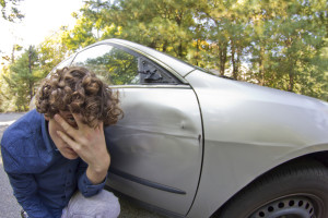 Silly man makes angry annoyed facial expression about dame to his car